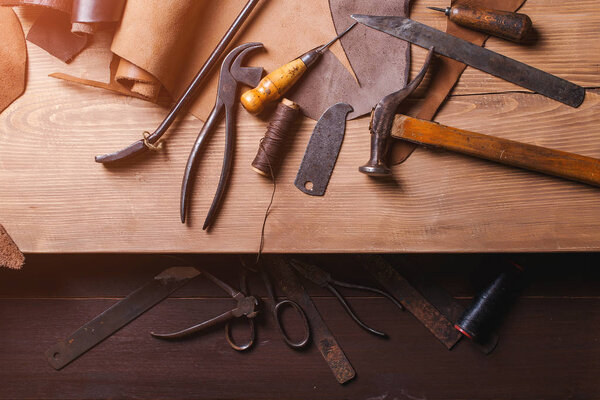 Cobbler tools in workshop on the wooden table . Top view.