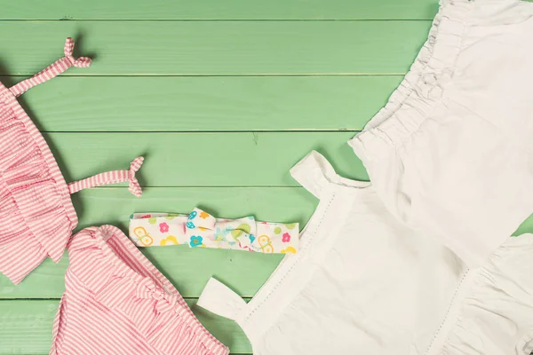 Conjunto de roupas da menina no fundo de madeira — Fotografia de Stock