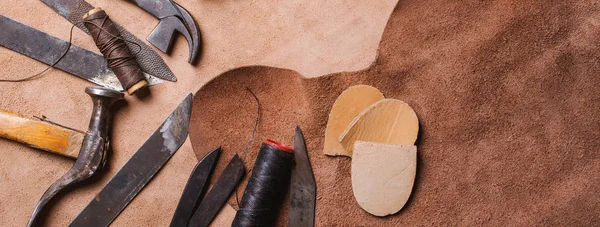 Cobbler tools in workshop on the wooden table. Вид сверху . — стоковое фото