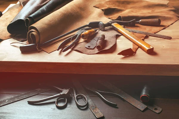 Skomakare verktyg i verkstaden på trä bordet. Ovanifrån. — Stockfoto