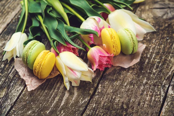 Macaroni colorati e bellissimi tulipani su ba di legno rustico scuro — Foto Stock