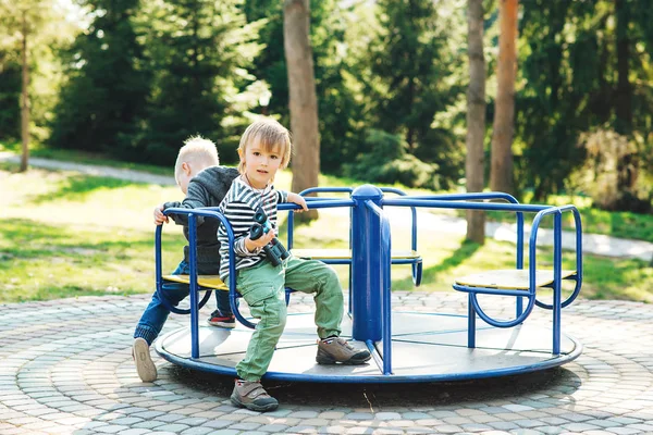 Dois meninos felizes brincando no playground em um parque . — Fotografia de Stock