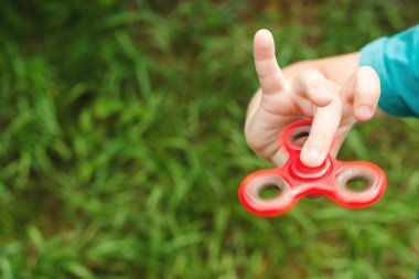 Sevimli çocuk Tri kıpır el Spinner açık havada ile oynuyor. Çocuklar ve yetişkinler için eller için modaya uygun oyuncak.