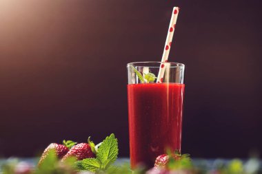 Siyah arka plan üzerine bir bardak taze çilek güler yüzlü.