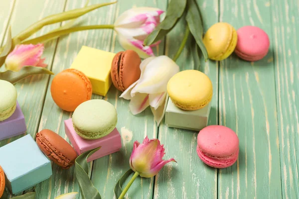 Hermosos tulipanes con coloridos macarrones sobre fondo de madera verde. Copiar espacio. Enfoque selectivo . — Foto de Stock