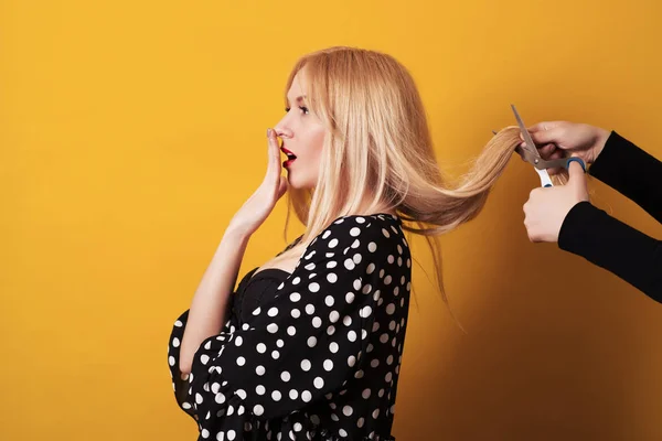 Mulher jovem loira com cabelos longos, fazendo o penteado. Tesoura corta as meninas cabelo. — Fotografia de Stock