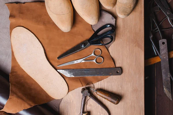 Cobbler tools in workshop on the wooden table . Top view. — Stock Photo, Image