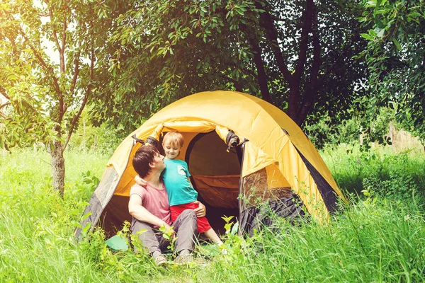 Sisters spending time in a tent on camping. Children using tablet playing games  online during summer vacation - a Royalty Free Stock Photo from Photocase