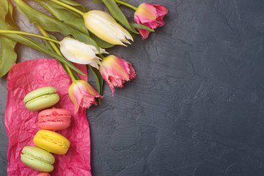 Renkli Lale ve macaroons siyah arka plan üzerine. Üstten Görünüm.