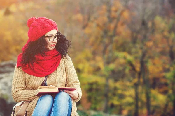 Piękna młoda kobieta, czytanie książki w parku i cieszyć się słoneczną pogodę. Koncepcja życia i jesień. — Zdjęcie stockowe