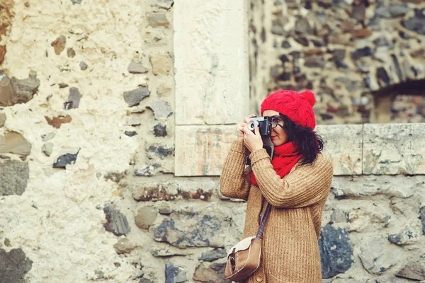 Eski arka planda retro kamera ile çekim güzel genç kadın duvar taşlar. Yaşam tarzı ve Turizm kavramı.