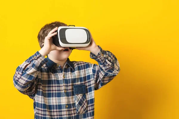 O menino vestindo óculos de realidade virtual sobre fundo amarelo . — Fotografia de Stock
