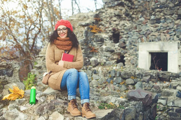 Gyönyörű fiatal nő, könyvével, egy parkban, és élvezi a napsütés. Életmód és őszi koncepció. — Stock Fotó
