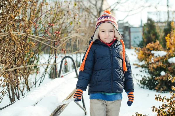 Милий маленький хлопчик, що виходить на вулицю в зимовий час. Малюк грає зі снігом . — стокове фото