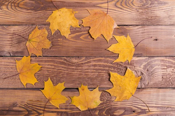 Cadre rond automnal de feuilles sur planches de bois, vue de dessus . — Photo