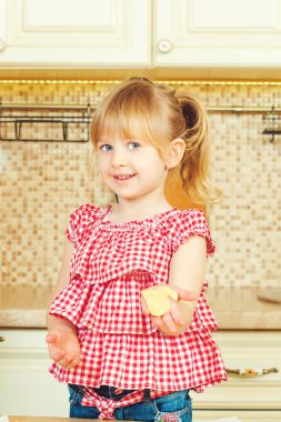 Sevimli küçük kız onun annesi fırında çerezleri bir mutfakta yardım.