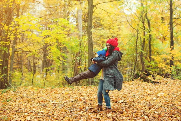 Mãe e filho feliz andando e brincando juntos no parque de outono . — Fotografia de Stock