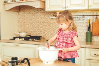 Sevimli küçük yardımcısı kız annesi bir mutfak pişirme yardım. Mutlu sevgi dolu aile ekmek hazırlama.