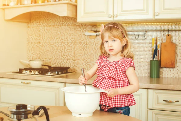 Милая маленькая помощница, помогающая матери готовить на кухне. Счастливая любящая семья готовит пекарню . — стоковое фото