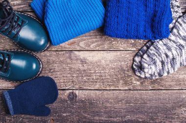 Sonbahar ya da kış kıyafeti. Çocuğun moda kıyafetler ve aksesuarlar ahşap arka plan üzerinde.