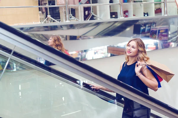 Elegante jongedame boodschappentassen houden en wandelen in handelscentrum. — Stockfoto