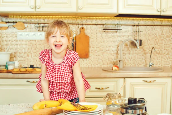 Schattig klein meisje helpt haar moeder bak koekjes in de keuken. — Stockfoto