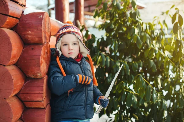 Cute little boy walking outdoor in winter time. Kid playing with icicle. — Stock Photo, Image
