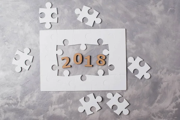 Nieuwjaar concept 2018. Puzzel op grijze concrete achtergrond. — Stockfoto