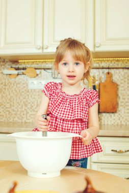 Sevimli küçük kız onun annesi fırında çerezleri bir mutfakta yardım.