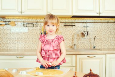 Sevimli küçük kız onun annesi fırında çerezleri bir mutfakta yardım.