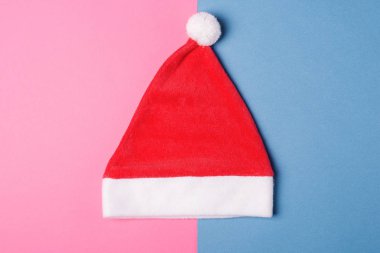 Noel Baba kırmızı şapka mavi ve pembe kağıt arka plan, en az tarzı üzerinde.