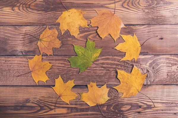 Cadre rond automnal de feuilles sur planches de bois, vue de dessus . — Photo