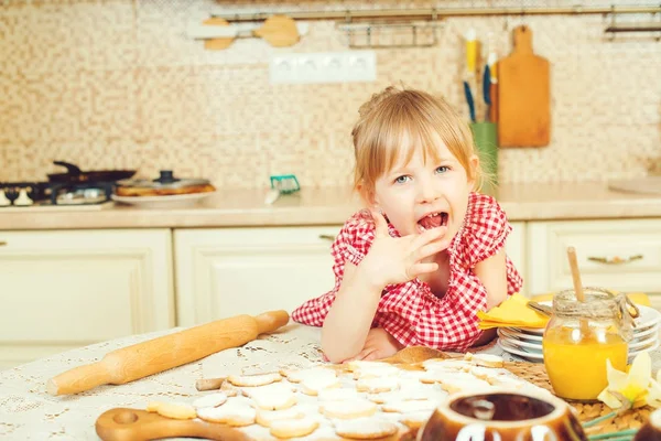 Cute little girl helping her mother bake cookies in the kitchen. — Stock Photo, Image