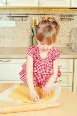 Sevimli küçük kız onun annesi fırında çerezleri bir mutfakta yardım.