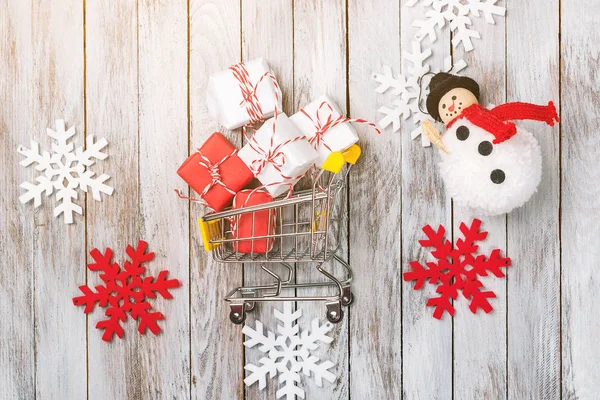 Karácsonyi ajándék dobozok kosárban egy fából készült háttér-dekoráció körül, felülnézet. Karácsonyi értékesítési koncepció. — Stock Fotó