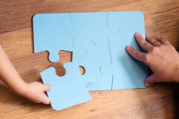 Mignon petit garçon résoudre puzzle sur un sol. Éducation et développement des jeunes enfants . — Photo