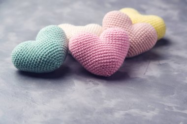 Bir sürü gri dokulu arka plan örme renkli kalpler. Metin için yer.