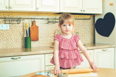 Sevimli küçük kız onun annesi fırında çerezleri bir mutfakta yardım.