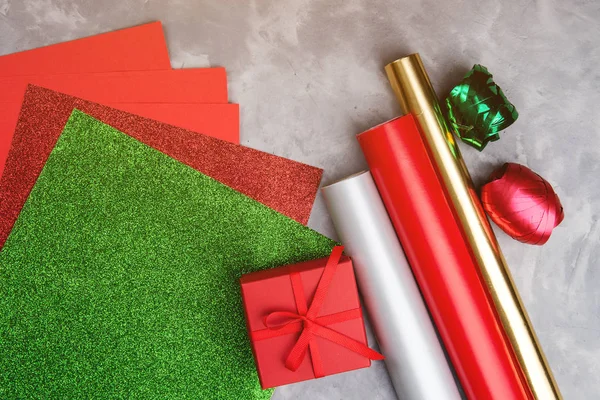 Conjunto de papel decorativo festivo e fita para embalar caixas de presente em fundo texturizado cinza . — Fotografia de Stock