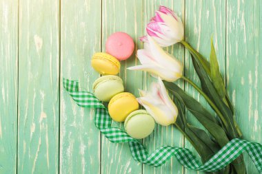 Renkli macaroons ve güzel ahşap zemin üzerine lale buketi. Üstten Görünüm. Kopya alanı.