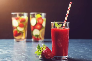 Çilek güler yüzlü ve sağlıklı Detoks içecekler siyah arka plan üzerine.