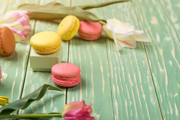 Belles tulipes avec des macarons colorés sur fond de bois verdoyant. Espace de copie. Concentration sélective . — Photo