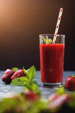 Siyah arka plan üzerine bir bardak taze çilek güler yüzlü.