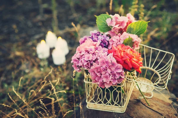 Красивый букет цветов гортензии в декоративной клетке на фоне природы . — стоковое фото