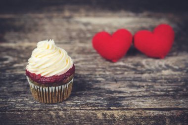 Ahşap arka plan üzerinde iki kırmızı kalp ile lezzetli kek.
