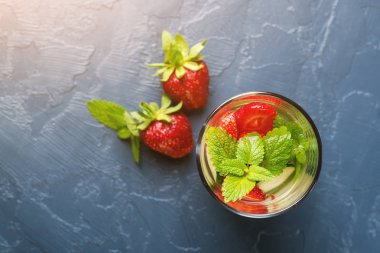 Çilek ve salatalık koyu arka plan üzerine bir bardak suyla detoks. Üstten Görünüm. Boşaltmak.
