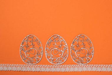 Paskalya kartı, dekore edilmiş turuncu zemin üzerine izole Paskalya yumurtaları.