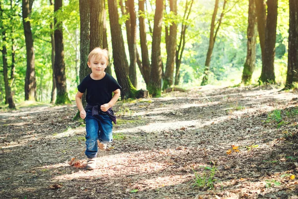 Щасливий блондинка біжить в сонячний день в лісі . — стокове фото