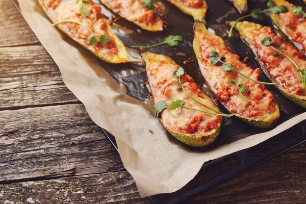 Calabacín relleno al horno con carne en una sartén sobre tablas de madera . — Foto de Stock