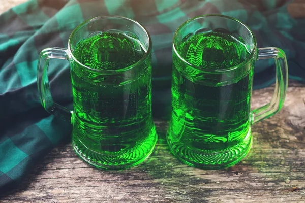 Two mug of green beer on rustic wooden background. — Stock Photo, Image